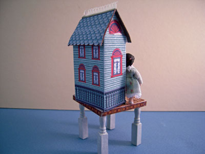 Loretta Kasza 1" scale hand crafted blue dollhouse on a table Loretta Kasza 1" scale hand crafted blue dollhouse on a table